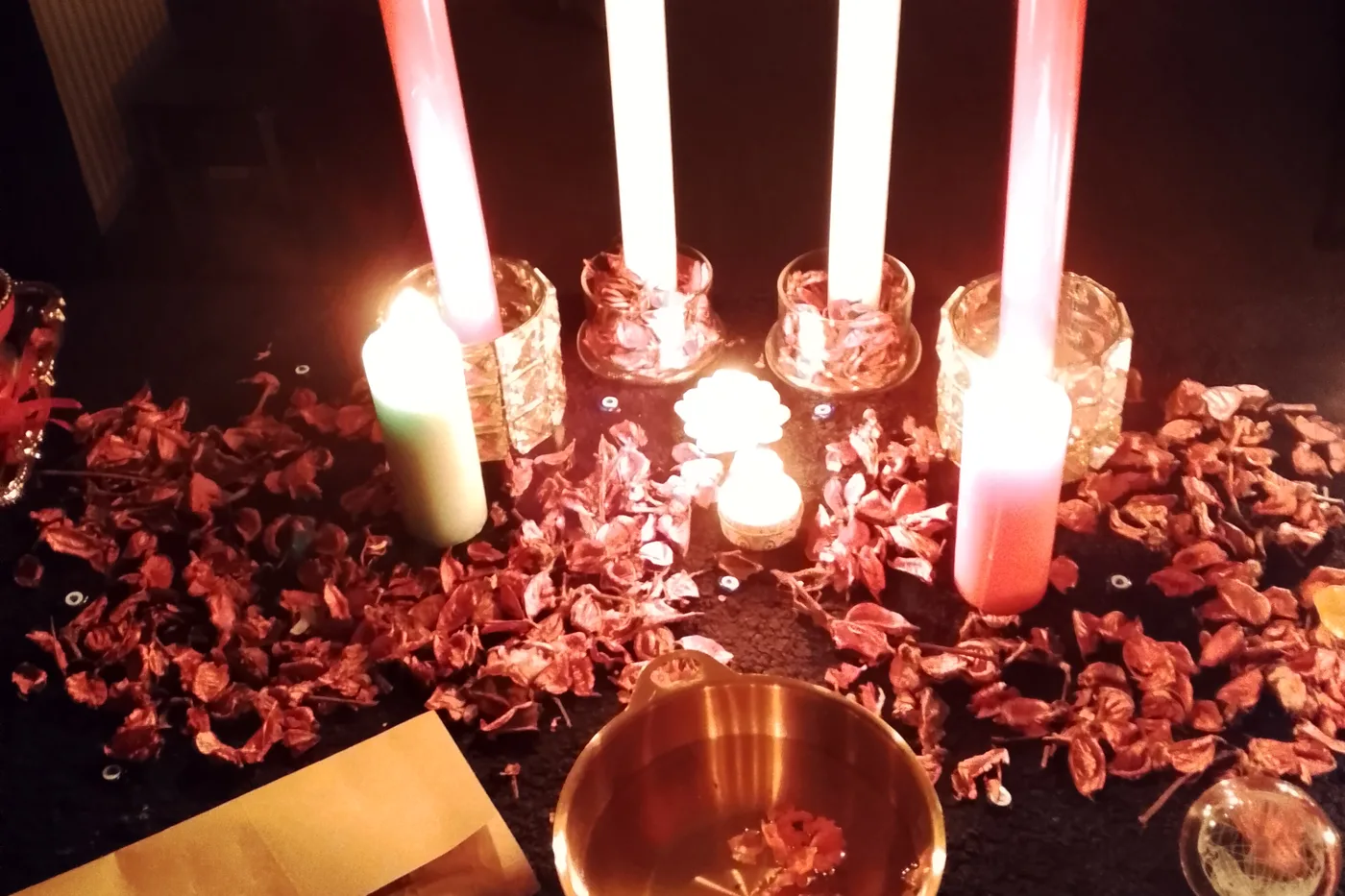 Melinora's altar by candlelight, salt and a folded name paper laid out for a casting